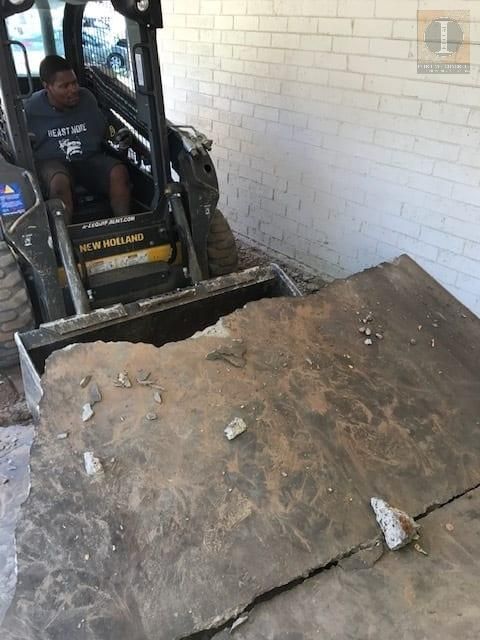 A man is driving a bulldozer in a garage.