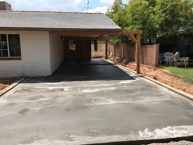 A concrete driveway is being built in front of a house.