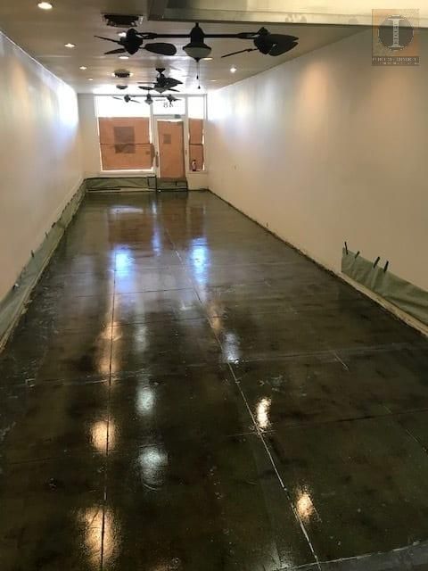 A long hallway with ceiling fans on the ceiling