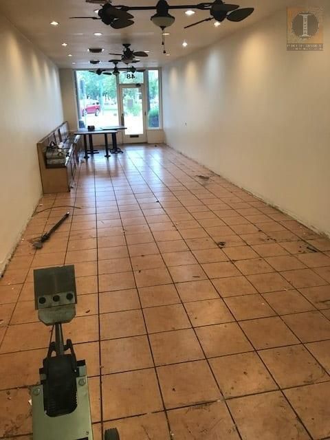 An empty room with tile floors and ceiling fans