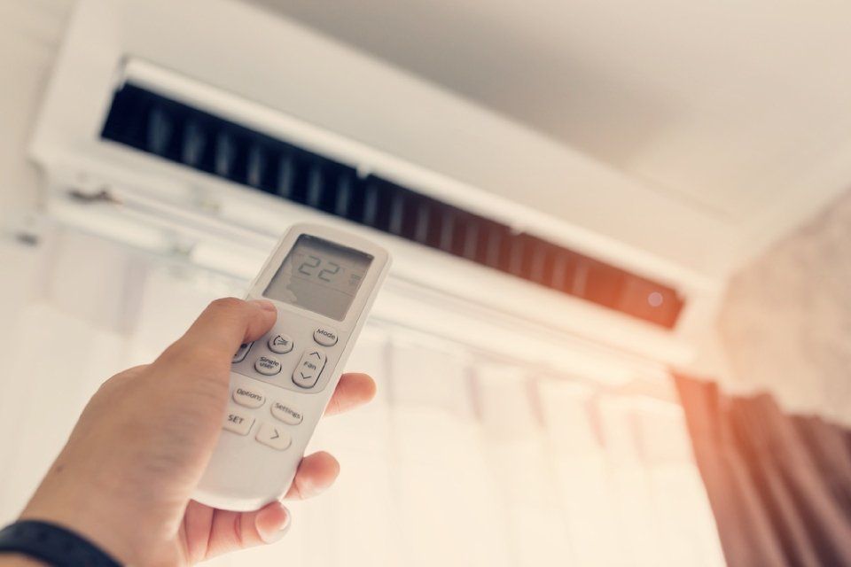 man changing the air conditioner temperature