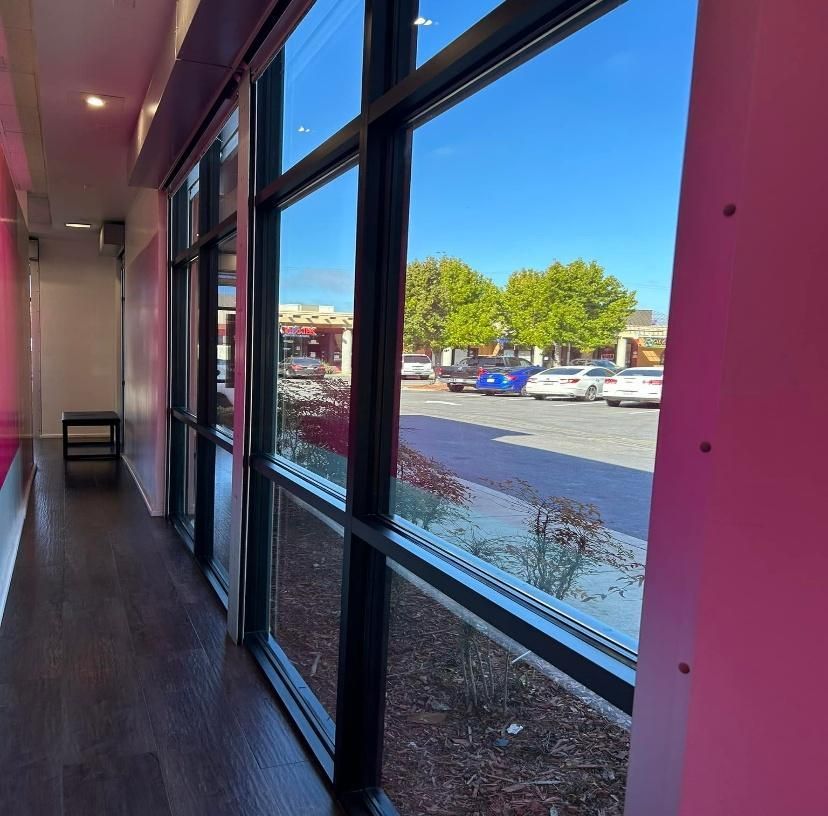 View from a store window looking out to a parking lot and a sunny day.