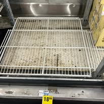 Dirty, empty refrigerator shelves.