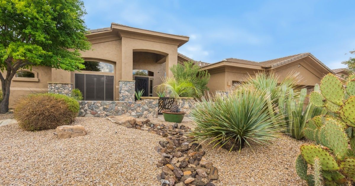 A Southern California property with a front yard full of xeriscaping and water-wise landscaping; rocks cover the yard.