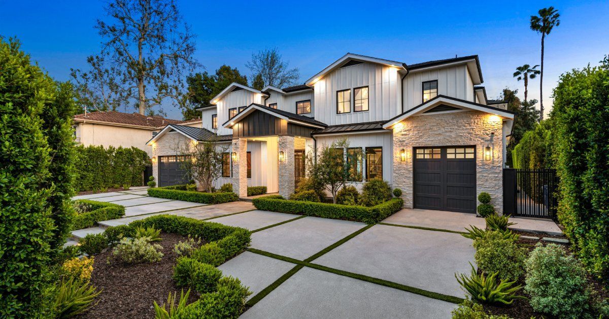 A California home with a professionally groomed front yard and driveway area. The hedges are even and lush green.