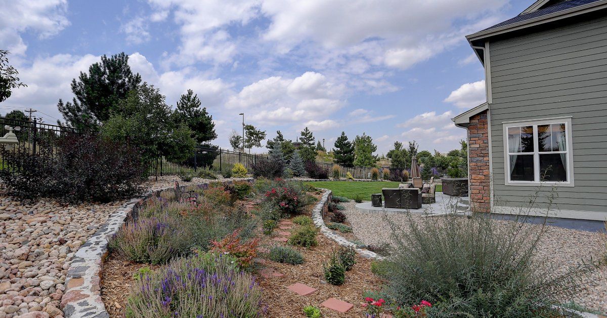 A beautiful home with a side yard full of drought-resistant plants and fresh landscaping, including mulch for the plants.
