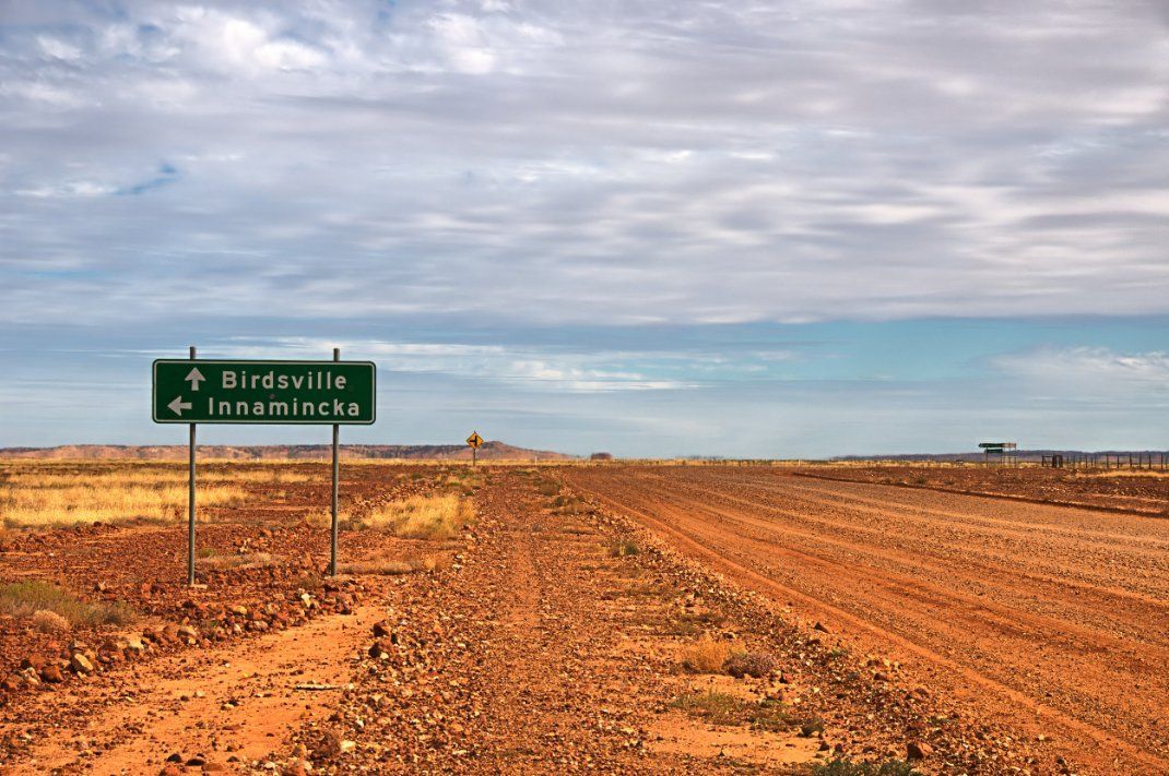 A Dirt Road with A Green Sign in The Middle of It — North West Queensland Painting in Birdsville, QLD
