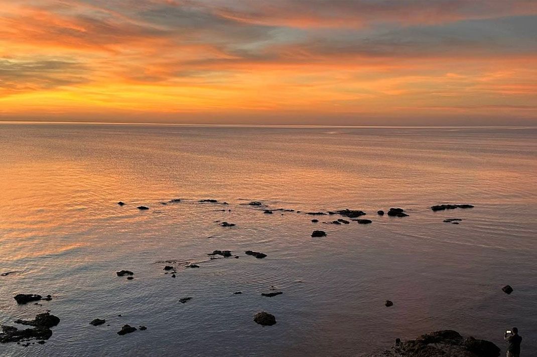 A Sunset Over a Large Body of Water with Rocks in The Foreground — North West Queensland Painting in Mornington Island, QLD