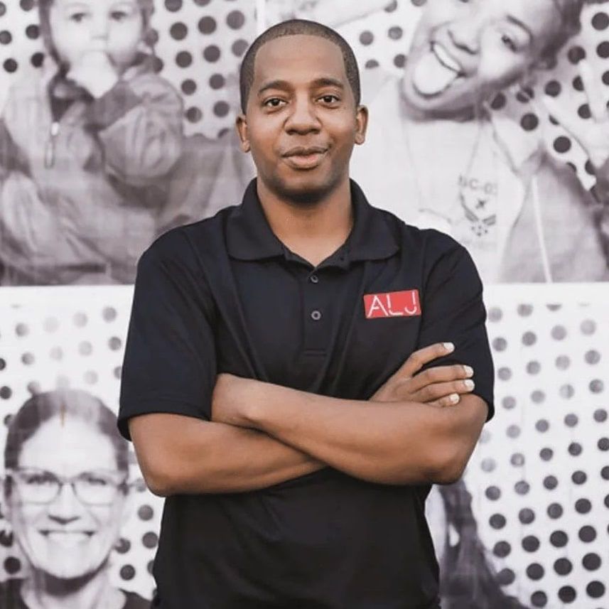 A man wearing a black shirt with the word alj on it