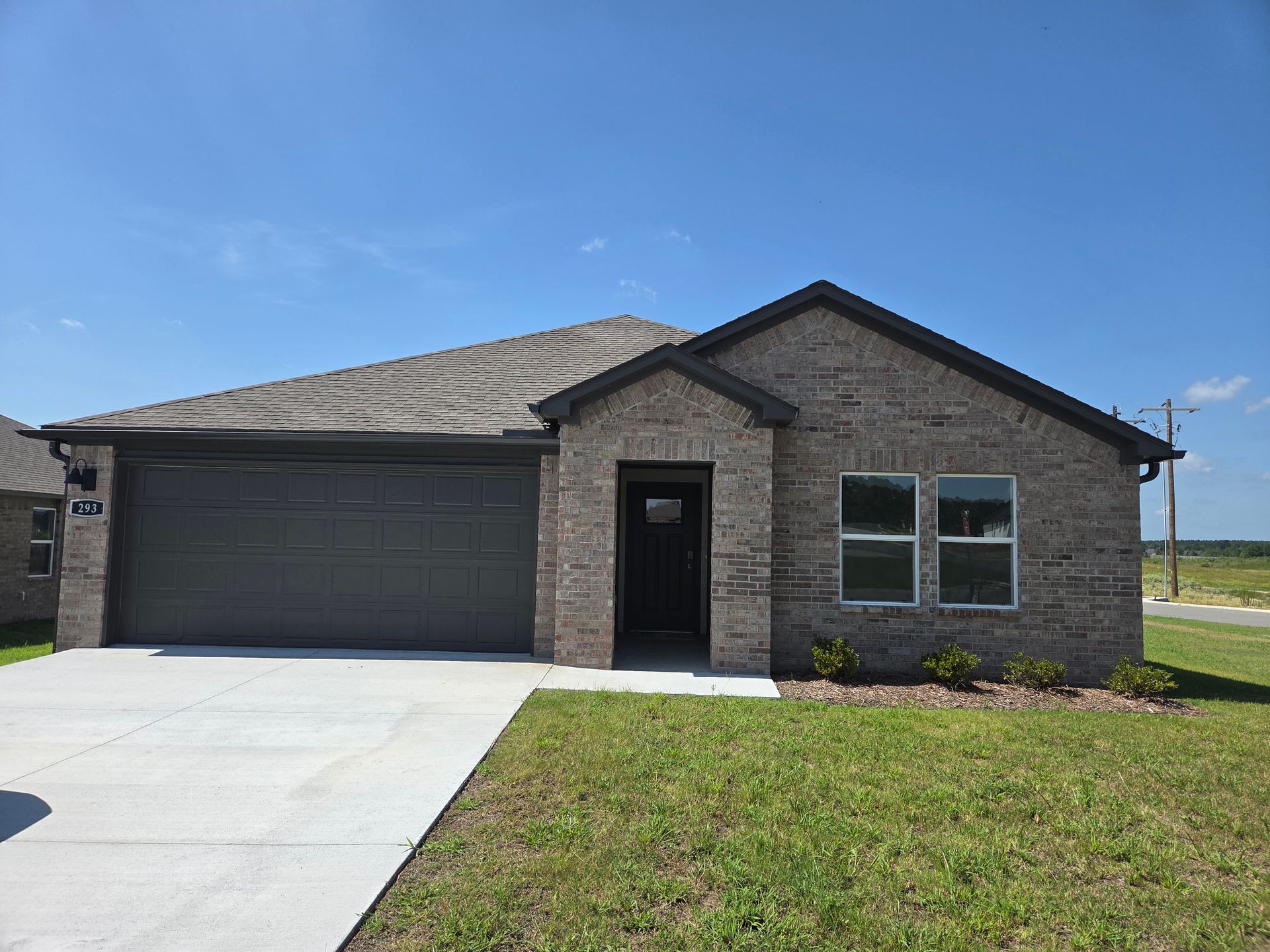 A brick house with a garage and a driveway in front of it.