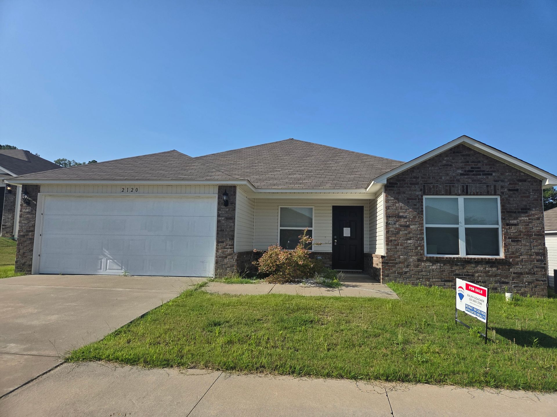 A house with a for sale sign in front of it.