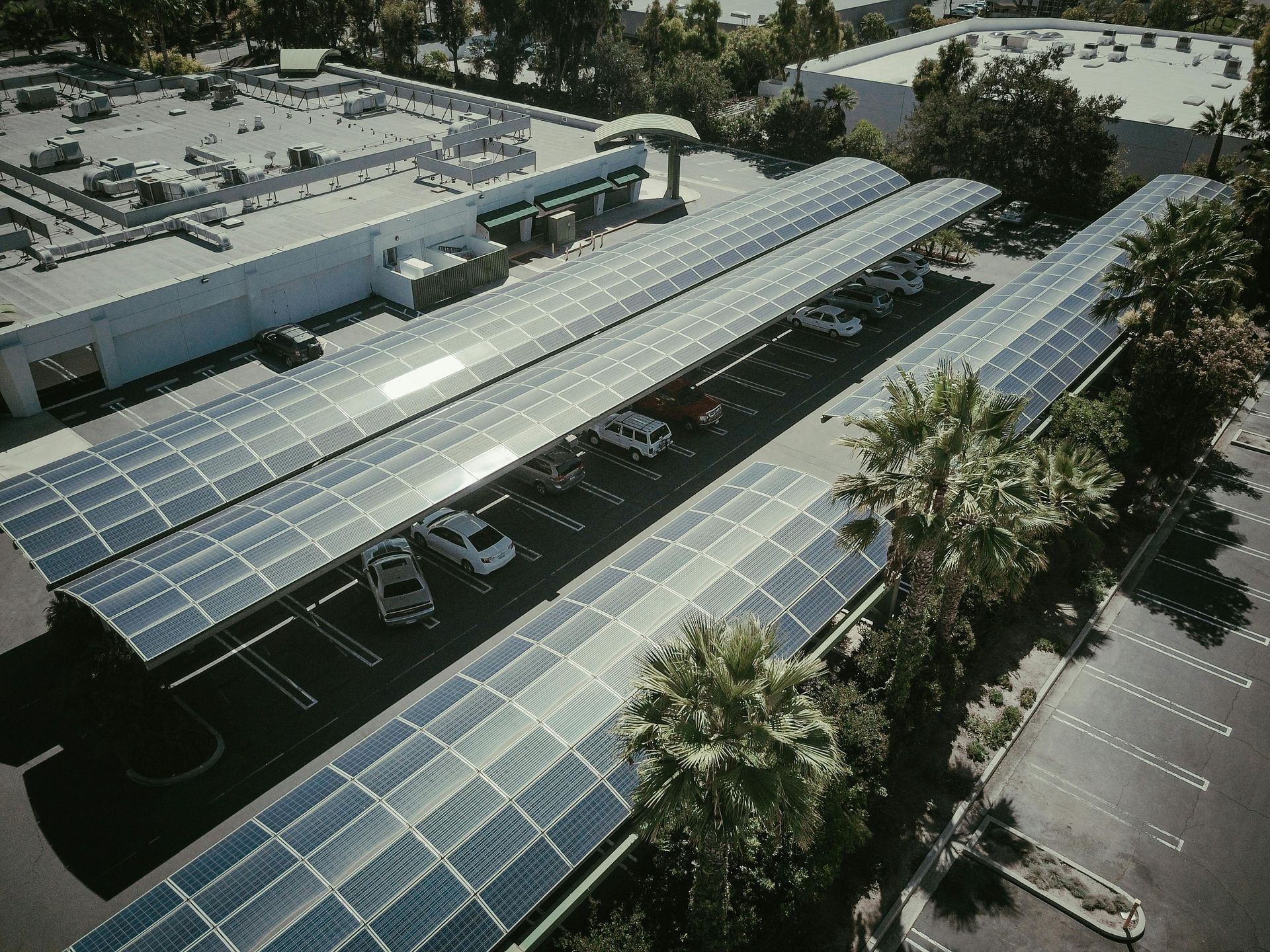 An aerial view of a parking lot covered in solar panels