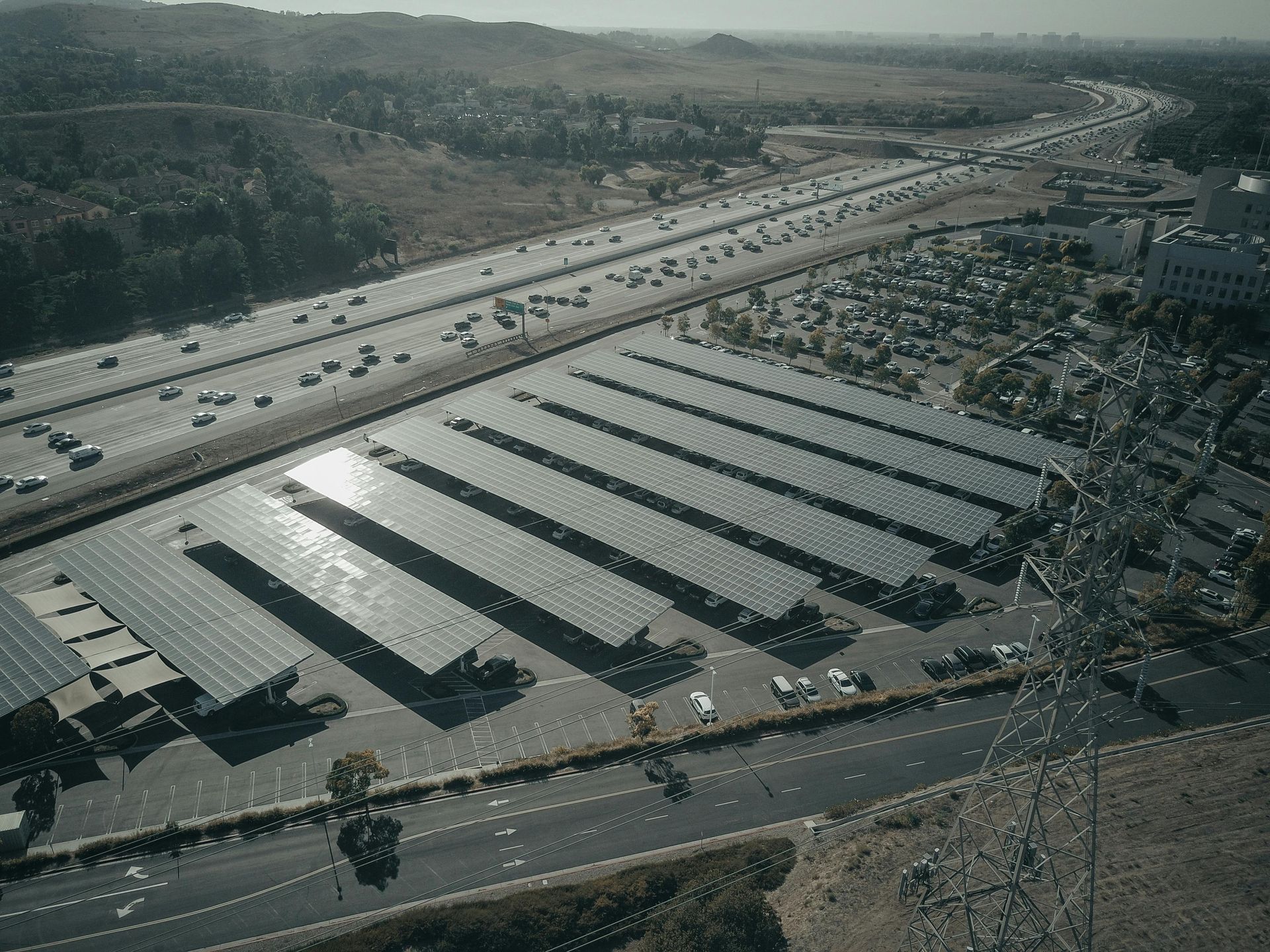 An aerial view of a parking lot with solar panels on the roofs.