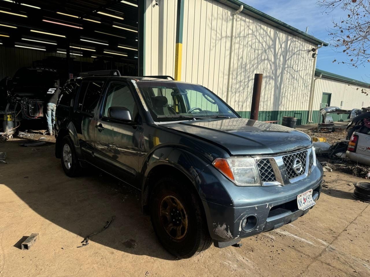 A nissan pathfinder is parked in front of a garage.