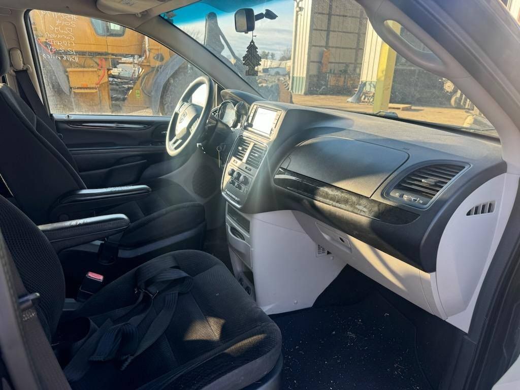 The interior of a minivan with a steering wheel and dashboard