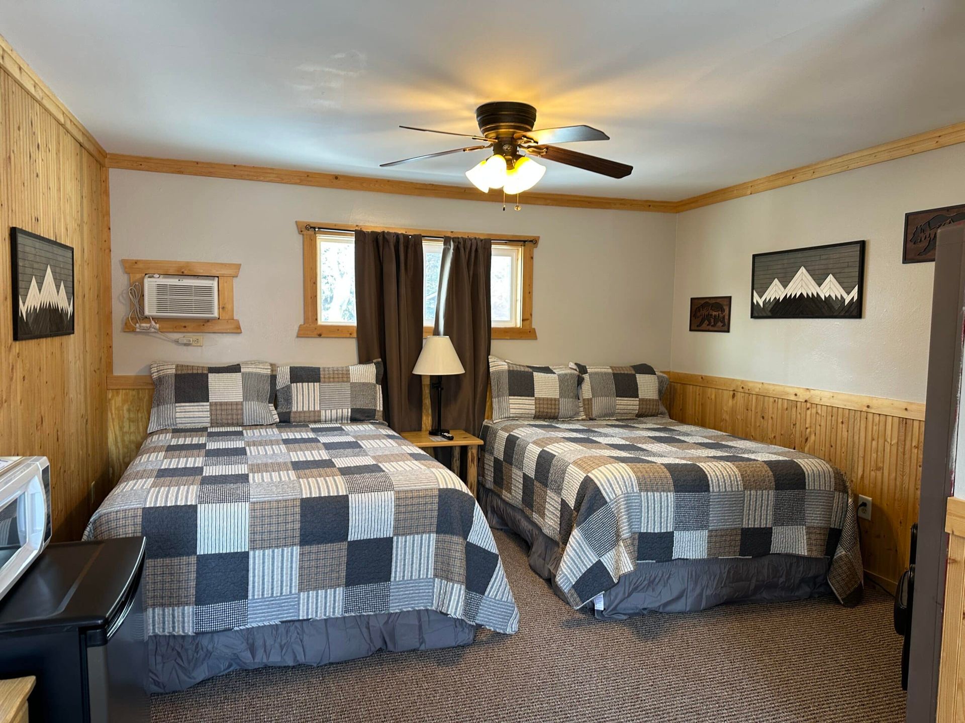 A bedroom with two beds and a ceiling fan.