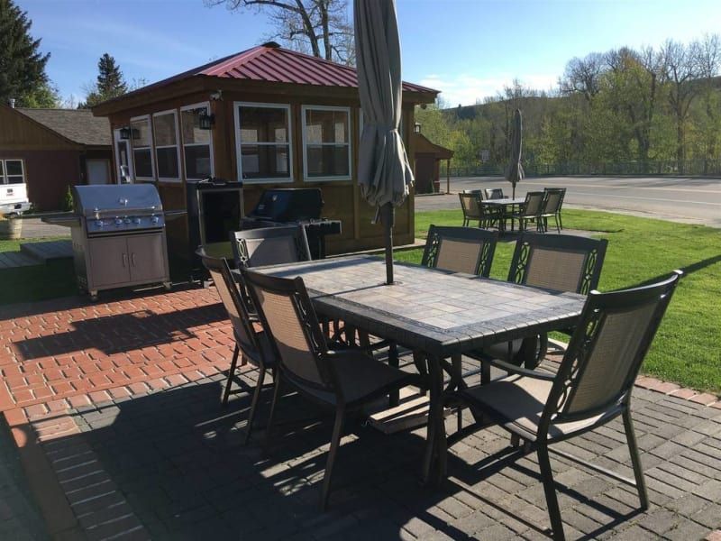 A table and chairs on a patio in front of a gazebo