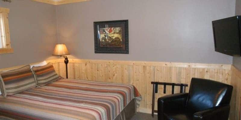 A bedroom with a bed , chair and television.