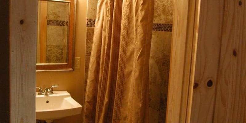 A bathroom with a sink , mirror and shower curtain.