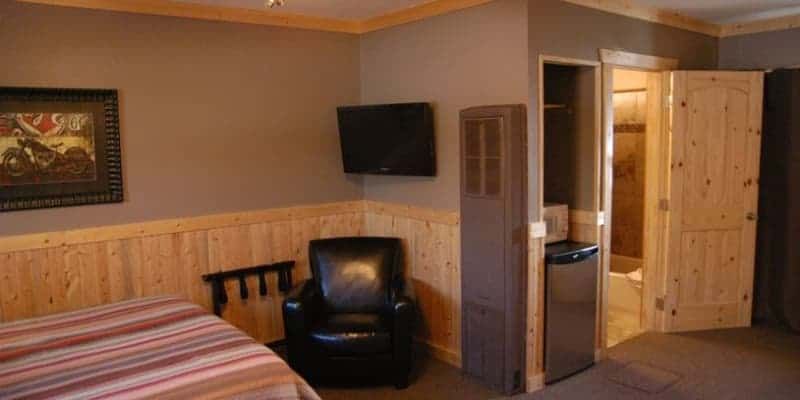 A bedroom with a bed , chair and television.