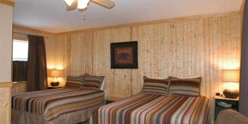 A bedroom with two beds and a ceiling fan.