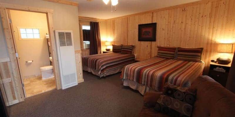 A hotel room with two beds , a toilet and a bathroom.