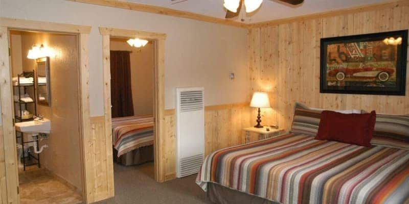 A hotel room with a bed , sink , and bathroom.