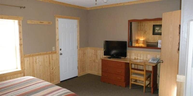 A bedroom with a bed , desk , chair and television.