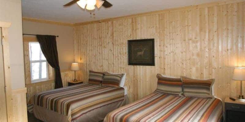 A bedroom with two beds and a ceiling fan.