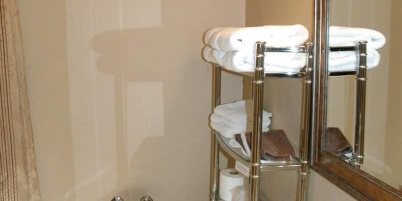 A bathroom with a towel rack and a mirror.