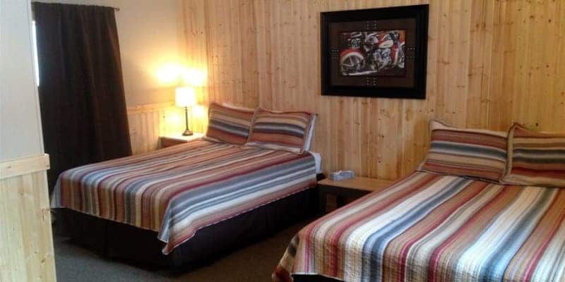 A hotel room with two beds and a picture on the wall.