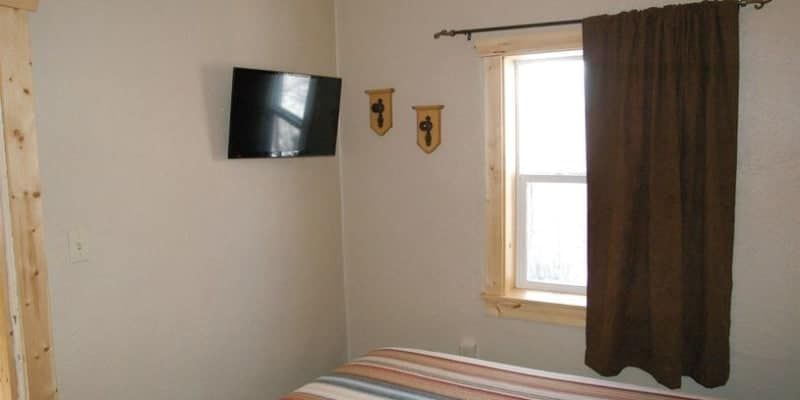 A bedroom with a bed , television , and window.