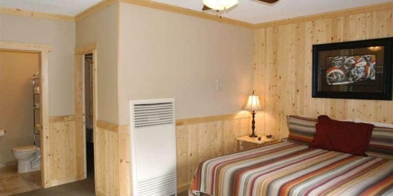 A bedroom with a king size bed and a ceiling fan.