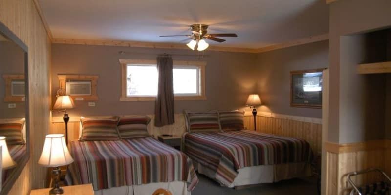 A hotel room with two beds and a ceiling fan