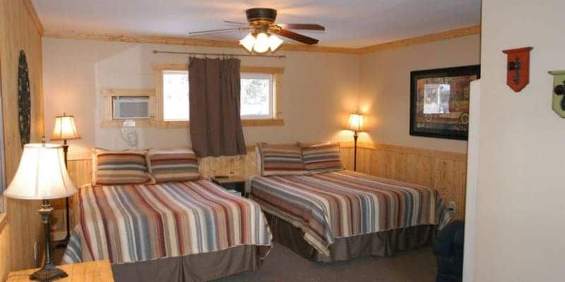 A hotel room with two beds and a ceiling fan