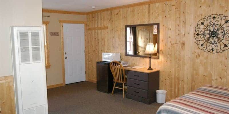 A hotel room with two beds , a desk , and a mirror.