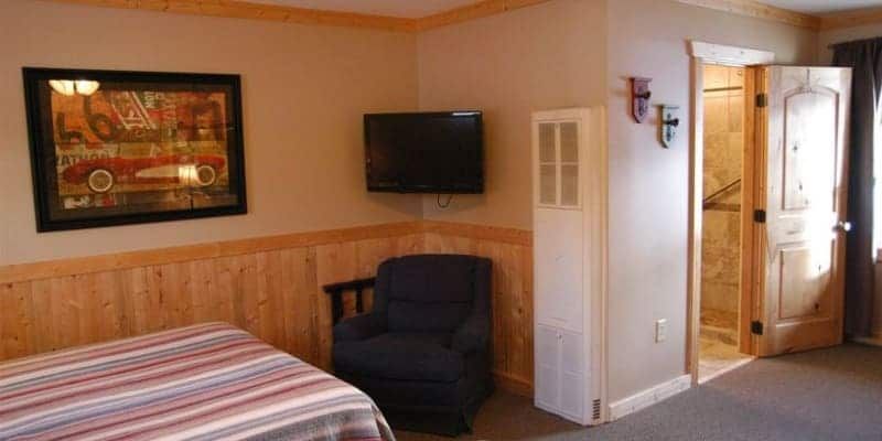 A bedroom with a bed , chair and television.