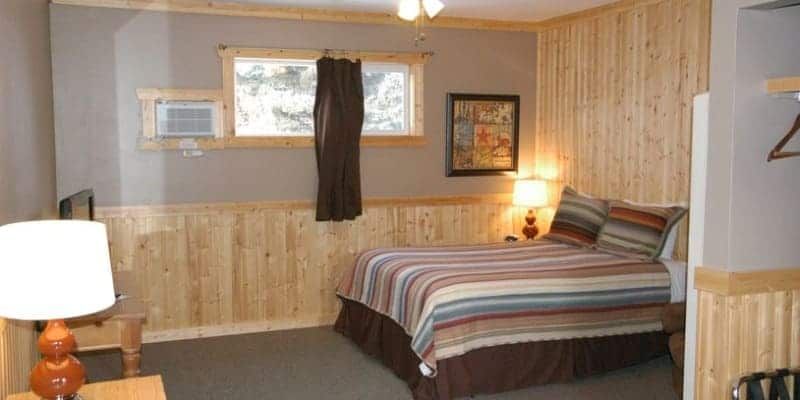 A bedroom with a bed , lamps , and a window.