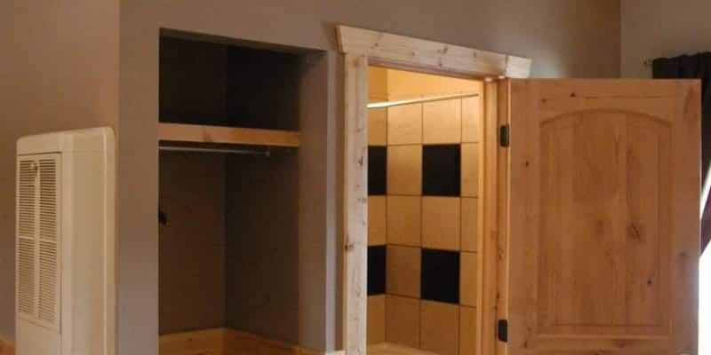 A bedroom with a closet and a door leading to a bathroom.