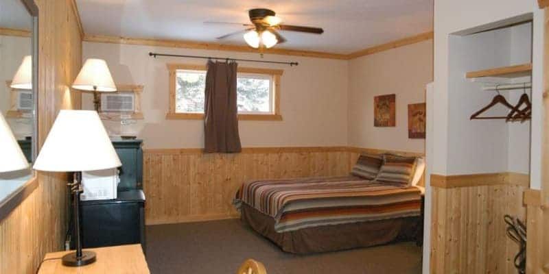 A hotel room with a bed and a ceiling fan