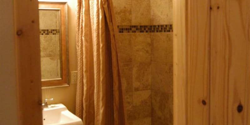 A bathroom with a sink , mirror and shower curtain.