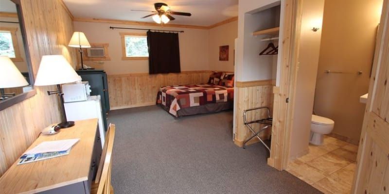 A hotel room with a bed , desk , and toilet