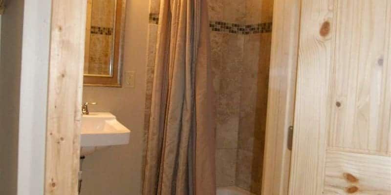 A bathroom with a sink , shower and mirror.