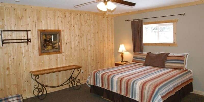 A bedroom with a king size bed and a ceiling fan.