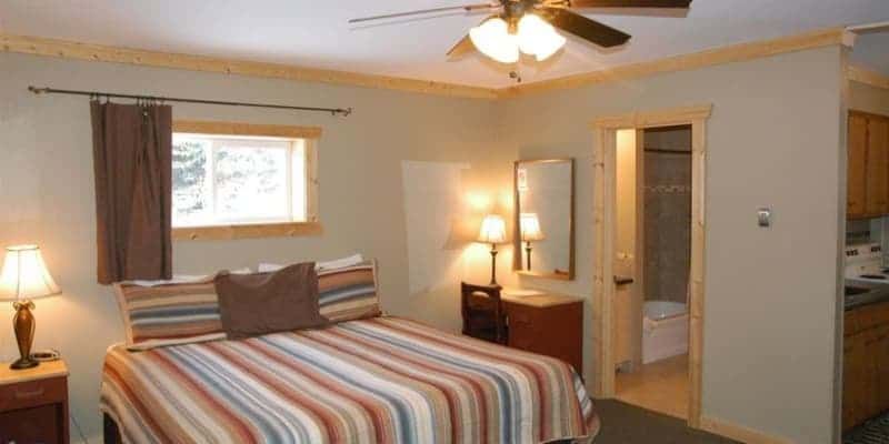 A bedroom with a king size bed and a ceiling fan.