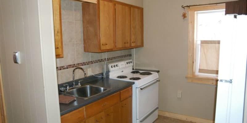 A kitchen with a stove , sink , and refrigerator.