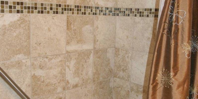 A shower curtain is hanging in a bathroom next to a tiled wall.