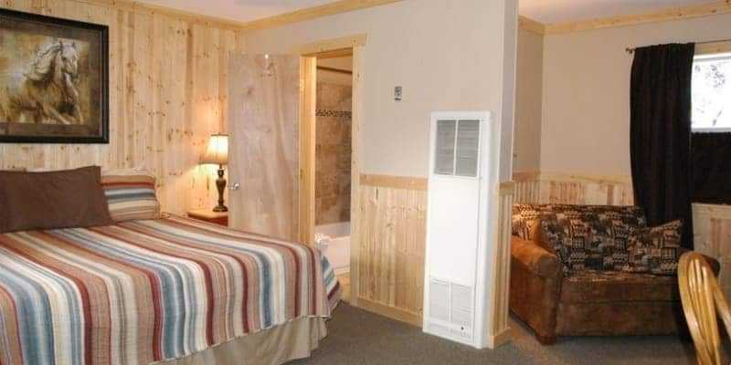 A hotel room with a bed , chair , and a picture on the wall.