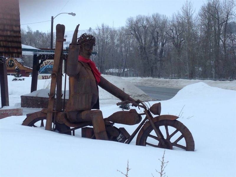 A statue of a man riding a motorcycle in the snow