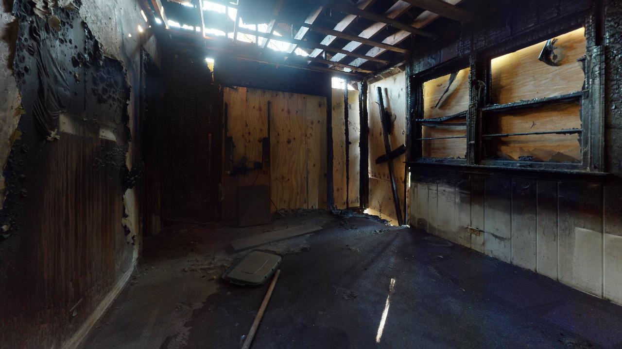 A dark room with wooden walls and a window.